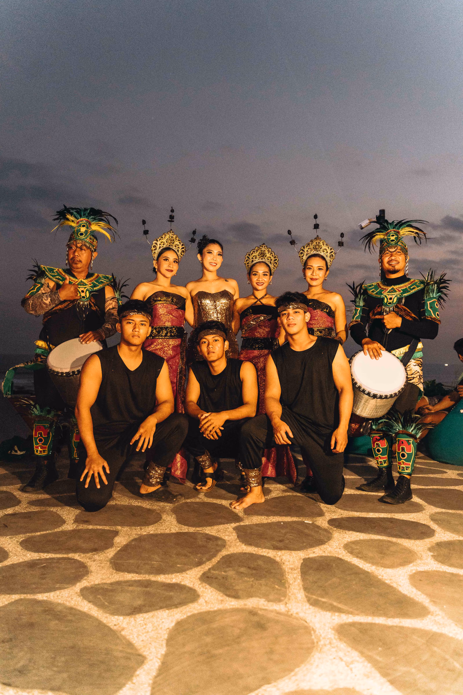 Ensemble of dancers and musicians posing together outdoors